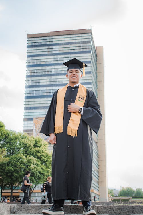 A Man in a Graduation Gown Standing Outside