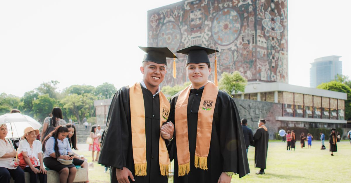 Alumni Examples Two Young Alumni Posing at a University Campus after a Graduation ...