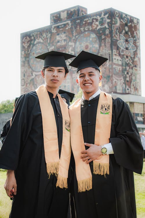 Young Men in Graduation Gowns Standing in front of the University of Mexico Building 