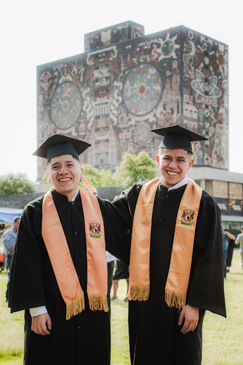 Young Men in a Graduation Gowns Standing in front of the University of Mexico Building 