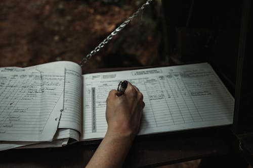 Free Close-up of a Man Writing in a Book  Stock Photo