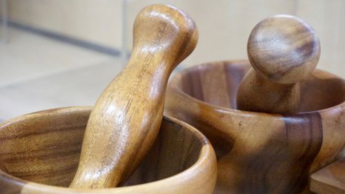 Free Close-up of a finely carved wooden mortar and pestle set, ideal for kitchen use. Stock Photo