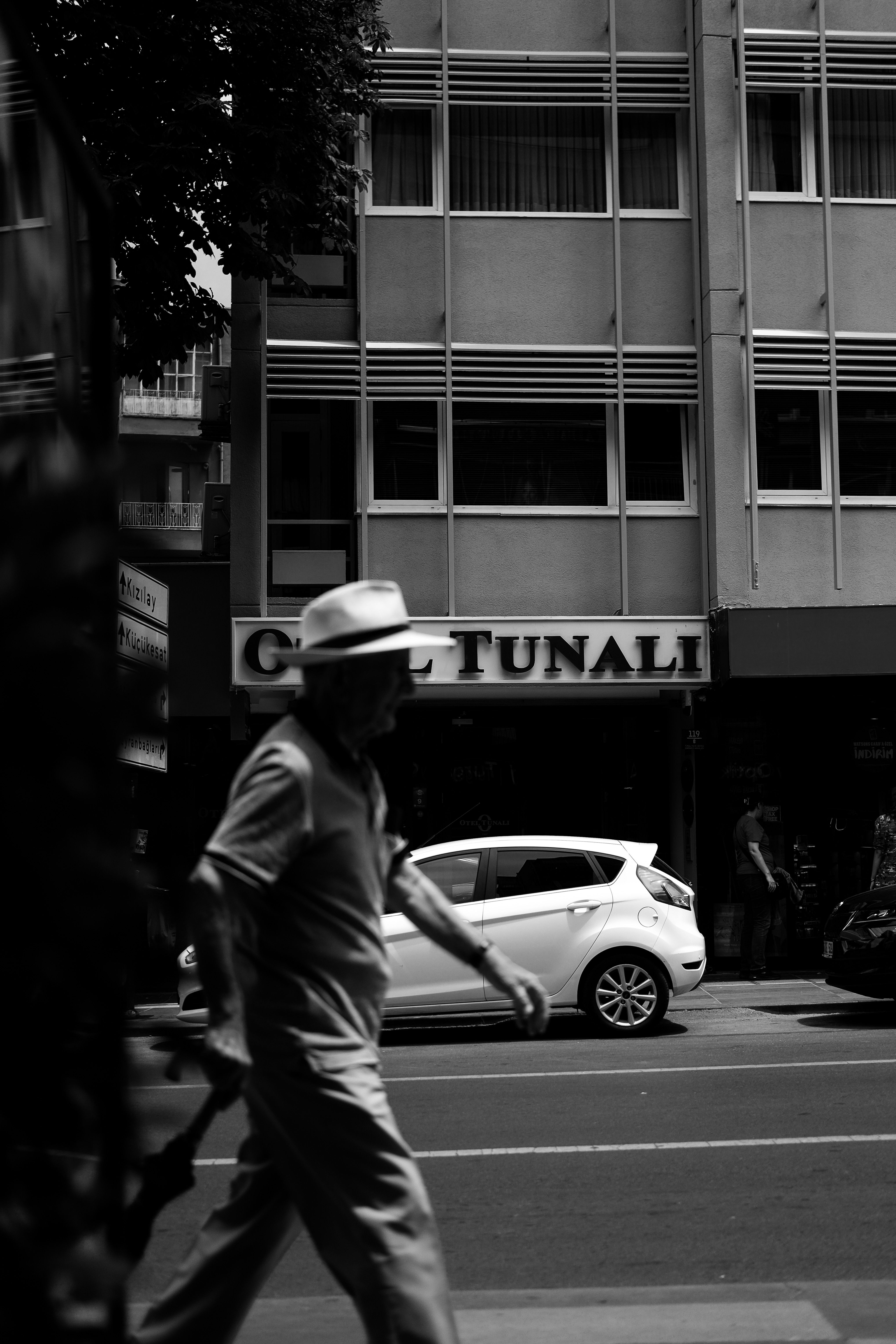A pedestrian walking past a Tunalı building in Ankara, Türkiye.