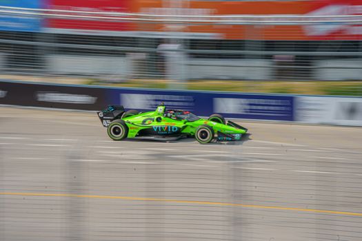 A vivid green Formula One car speeding on the track in Toronto, Canada.