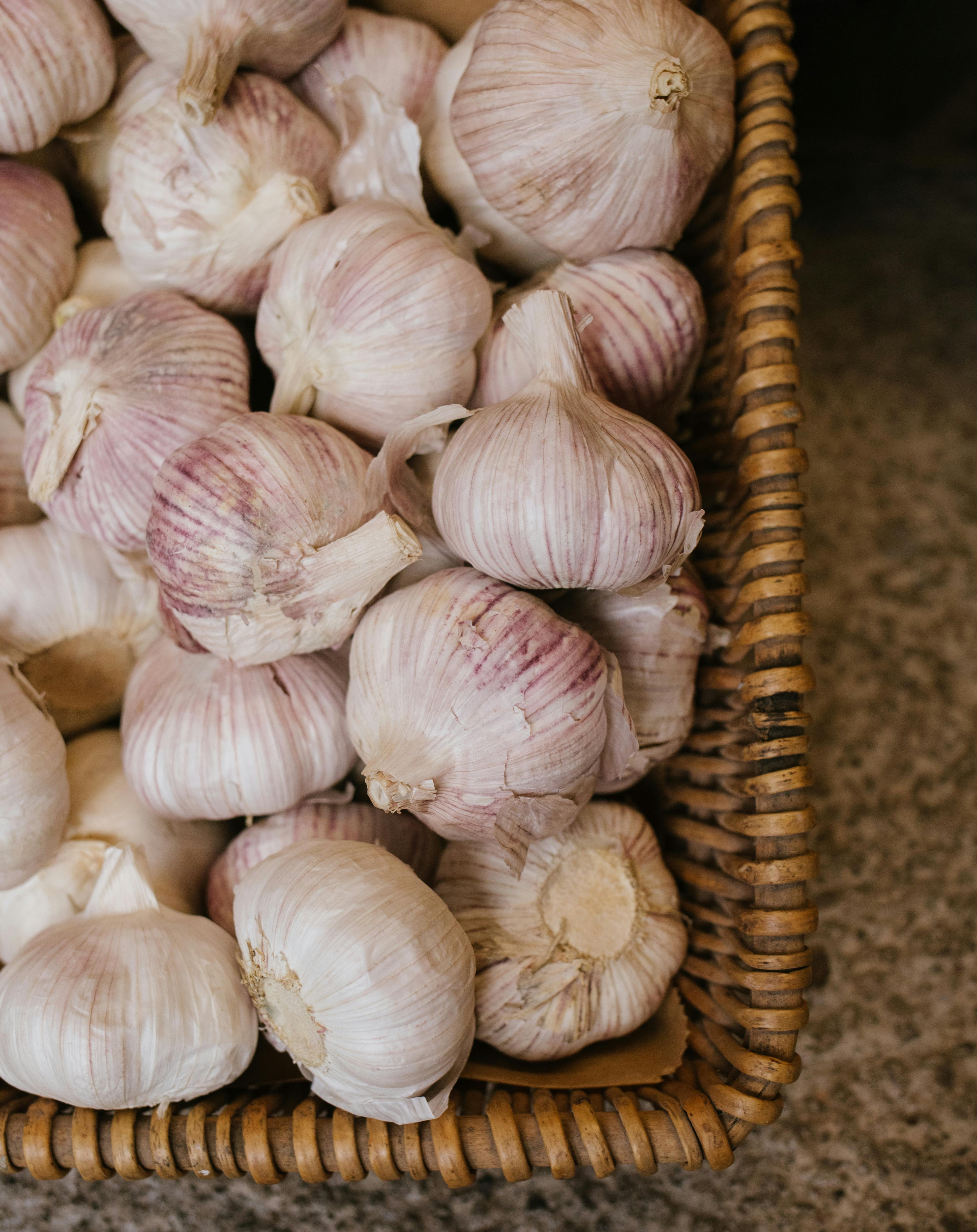 Organic garlic cloves in a woven basket, emphasizing fresh and healthy living.