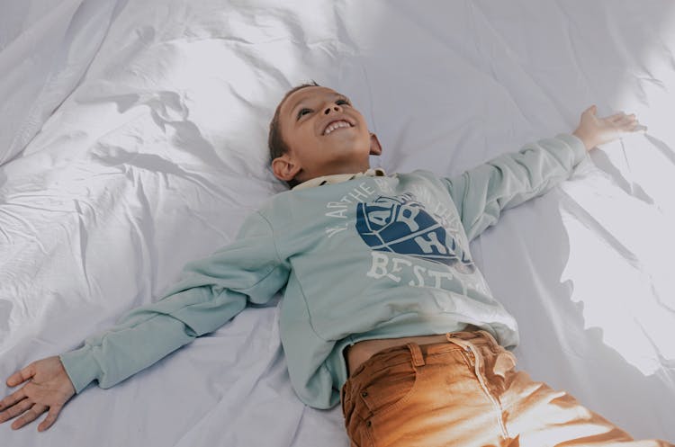 Little Boy Lying On Bed