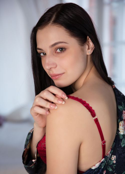 Free Portrait of a confident woman in red lingerie against an indoor backdrop. Stock Photo