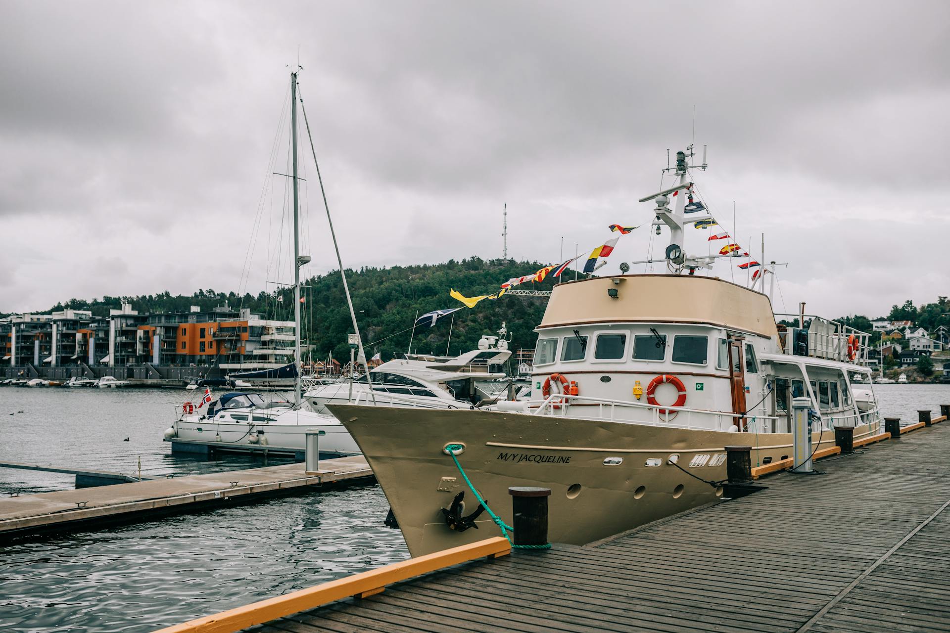 Beautiful harbor scene with a yacht and boats docked in a serene setting. Ideal for travel and maritime themes.