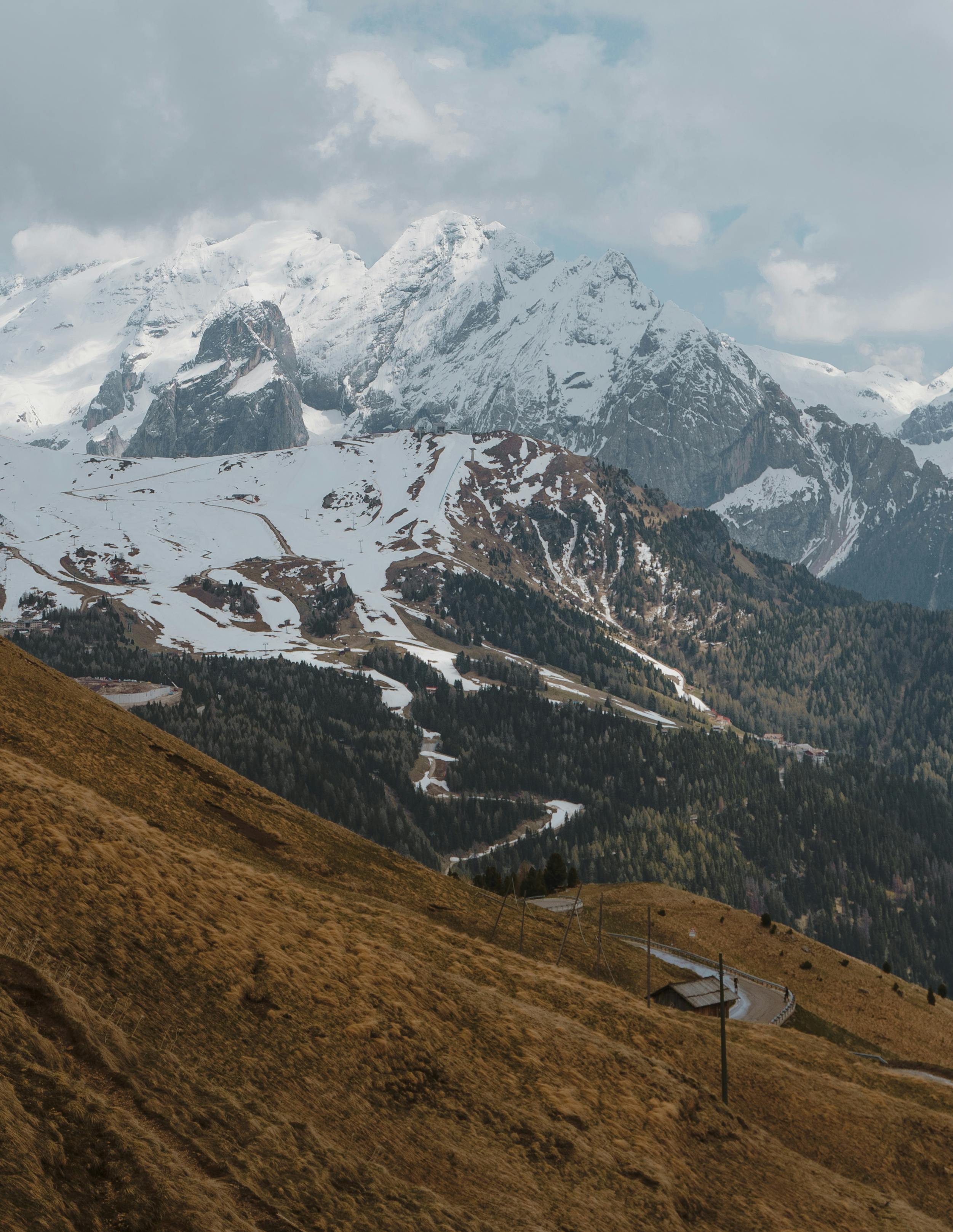 Breathtaking view of snow-capped mountains with a winding road through the alpine terrain.
