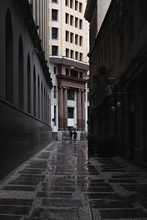 Man Walking Between Buildings