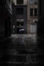 市区阴暗多雨的小巷里，一个人打着雨伞
