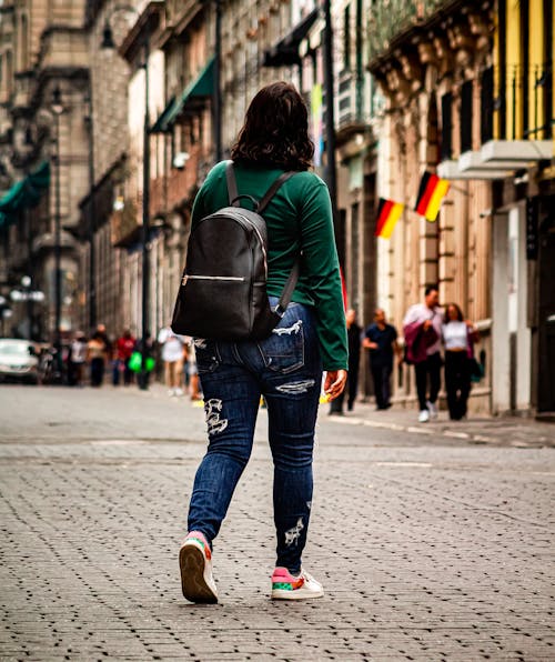 Woman with Backpack Walking on Street