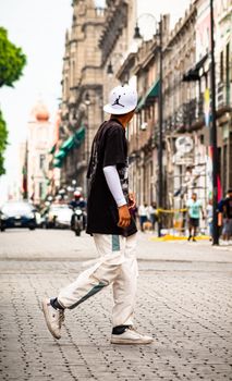 A man walking down the historic streets of Puebla City, showcasing urban style.