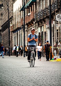 Man cycling on a cobblestone street in Puebla, Mexico surrounded by historic architecture.