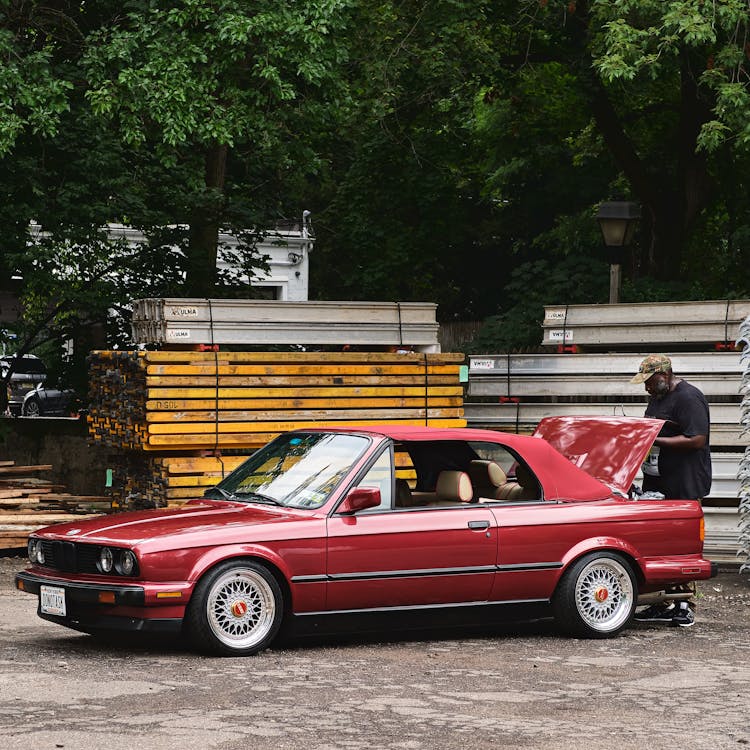 Man Repairing Red BMW