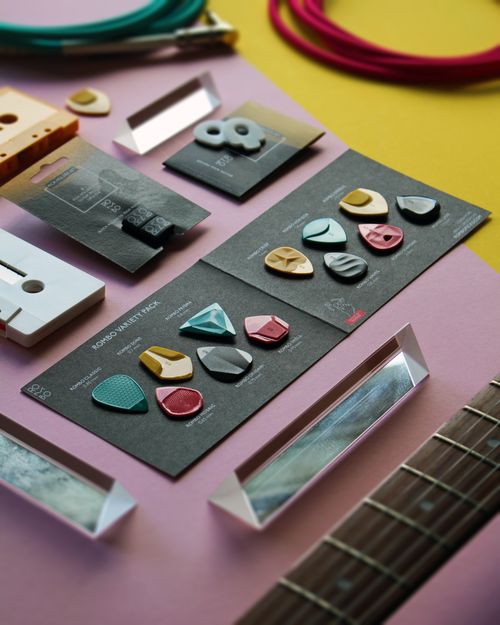 Free A display of colorful guitar picks and accessories arranged artistically on a table, showcasing music equipment. Stock Photo