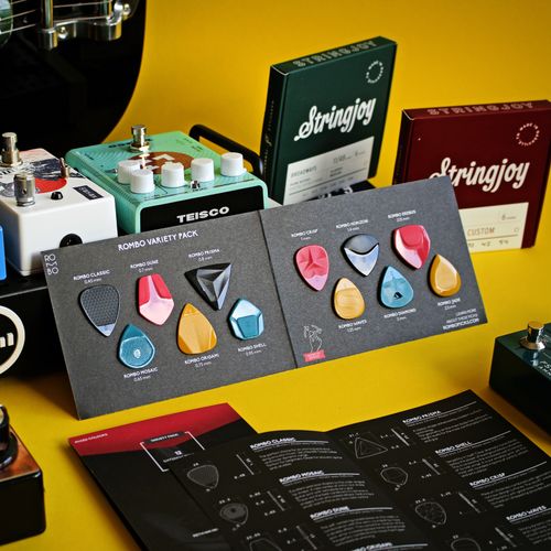 Free Vibrant display of guitar picks with music accessories on a yellow background. Stock Photo