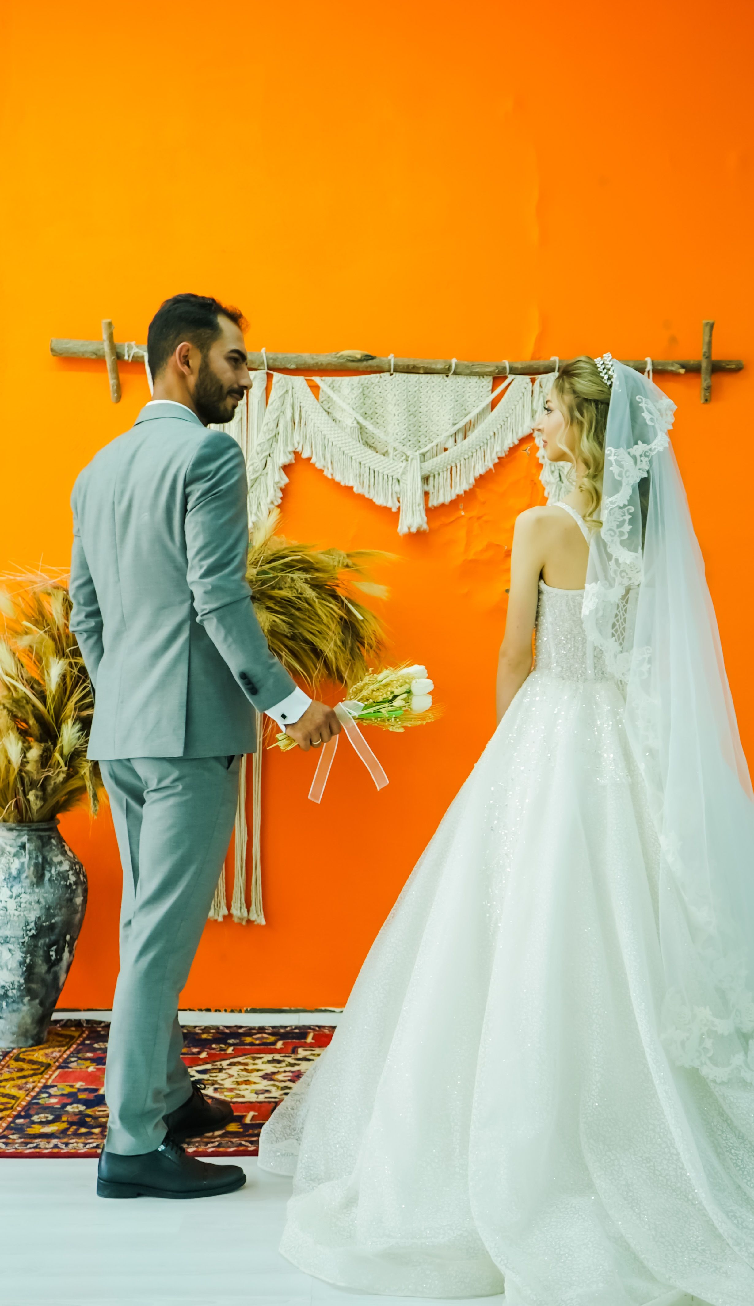 Bride and groom in a boho-style wedding ceremony with vibrant decor.