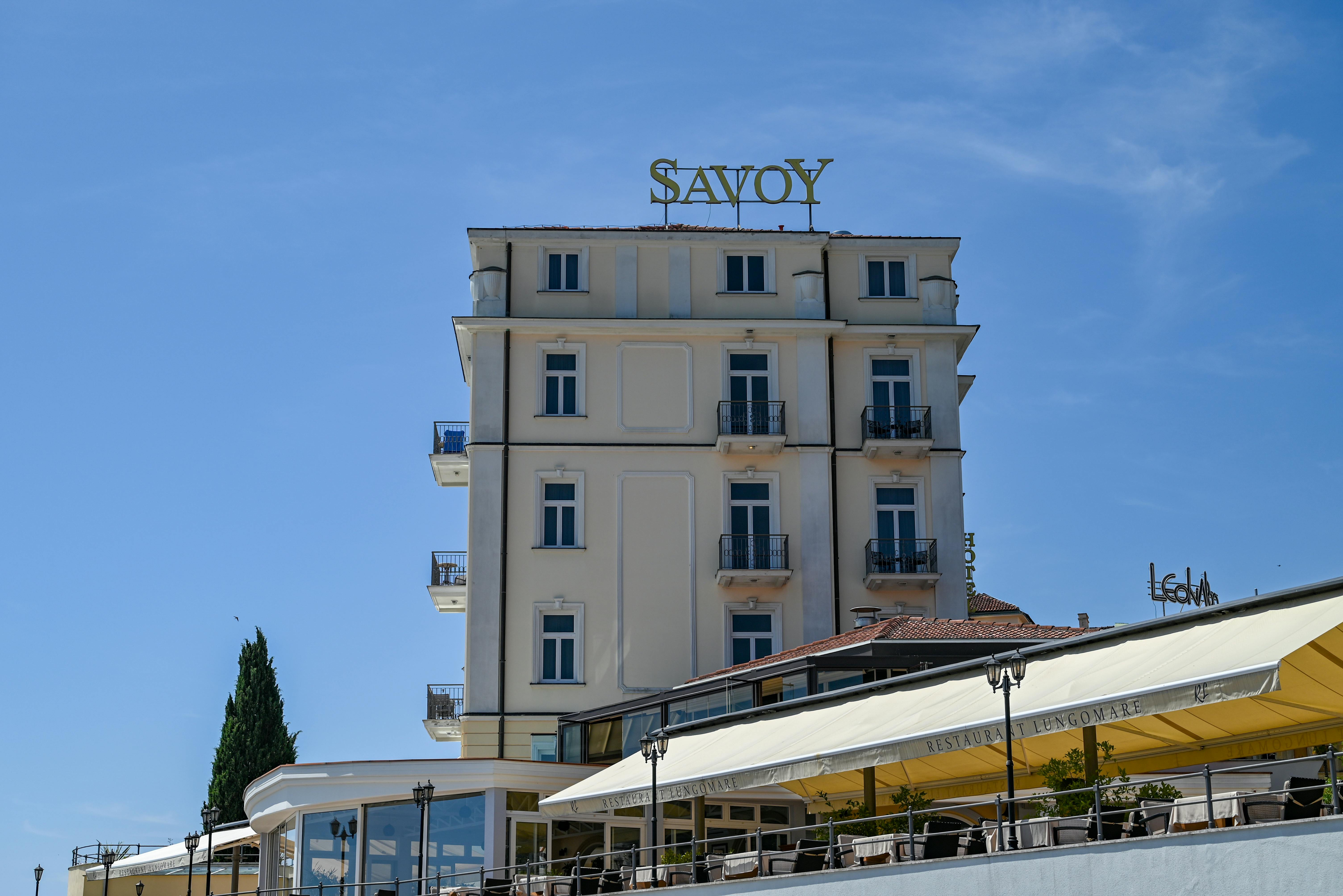 A low angle view of the Savoy Hotel with clear blue skies in Opatija, Croatia, showcasing its elegant architecture.