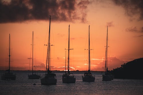 Silhouetted Sailboats on the Shore at Sunset 