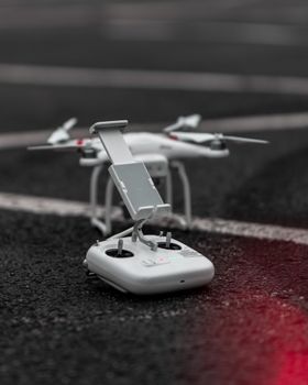 Close-up of a modern drone and controller on asphalt. Ideal for technology and innovation concepts.