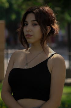 A young woman with a stylish haircut poses outdoors in Lima, enhancing the natural backdrop.