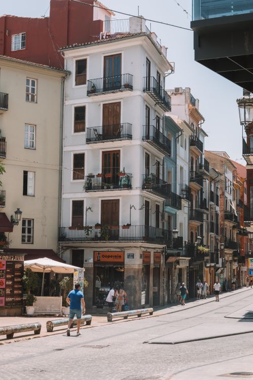 Free An urban street in Valencia, Spain showcasing traditional architecture under a sunny sky. Stock Photo