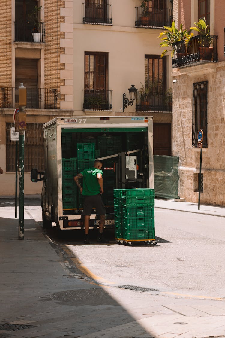 Man Loading Crates Onto Delivery Truck