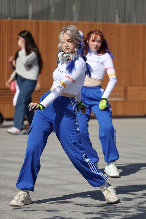 Free Two young women performing an energetic street dance outdoors in casual attire. Stock Photo