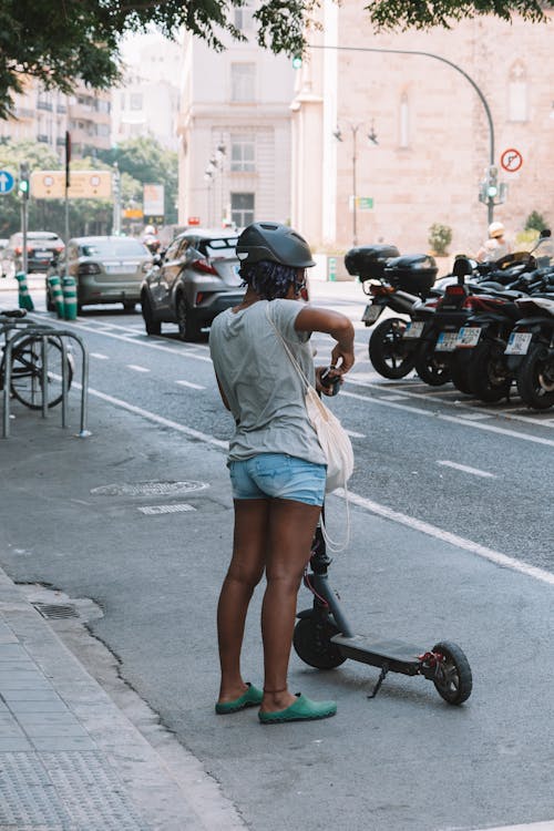 Woman with a Scooter on the Street in City 