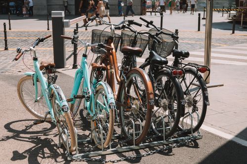 Free Group of bicycles in a stand on a sunny street in Valencia, showcasing urban life. Stock Photo