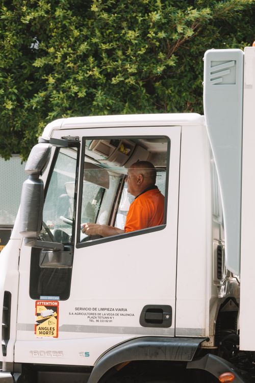 Free Driver in an urban truck, servicing streets in Valencia. Stock Photo
