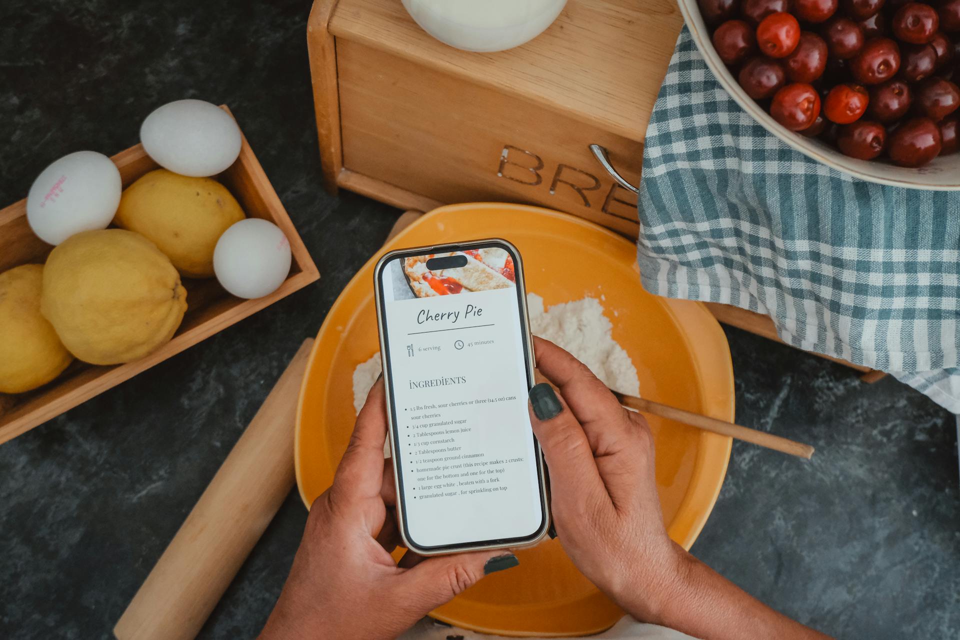 Woman Hands Holding Cellphone with Recipe on Screen