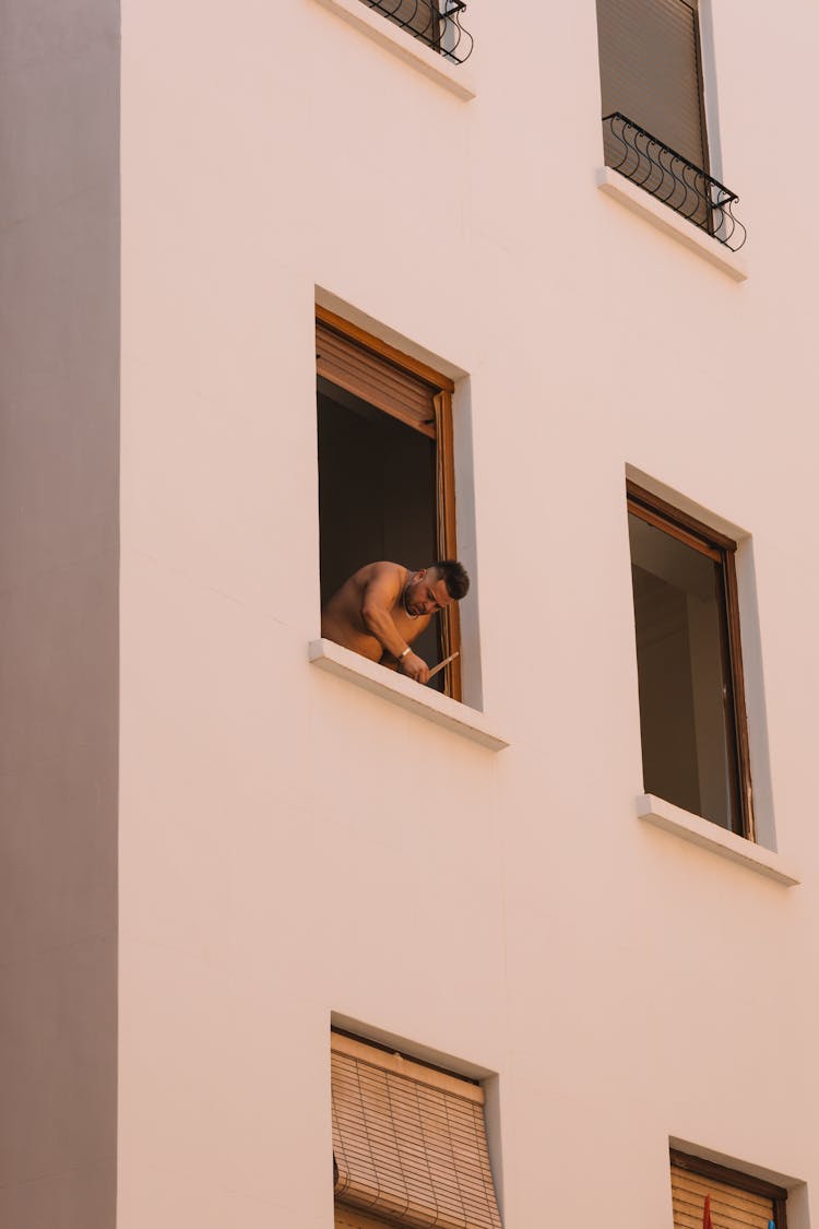 Man Standing In Building Window