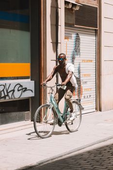 Cyclist enjoying a sunny day on the sidewalks of Valencia, Spain.
