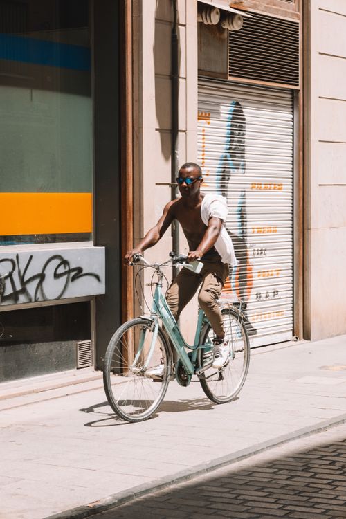 Free Cyclist enjoying a sunny day on the sidewalks of Valencia, Spain. Stock Photo
