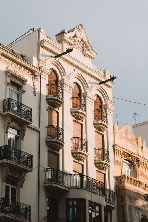 Free Elegant architecture with ornate balconies in Valencia at sunset, showcasing Mediterranean design. Stock Photo