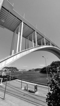 Striking black and white image of Porto's modern bridge spanning across the Douro River, showcasing architectural elegance.