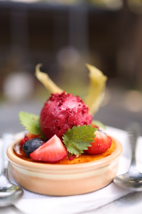 Free Close-up shot of a creme brulee topped with berries and mint leaves, perfect for food enthusiasts. Stock Photo