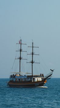 A stunning view of a sailboat voyaging on the blue waters of Antalya, Türkiye, against a clear sky.
