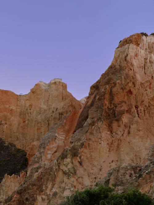 Free Breathtaking view of the red cliffs in Portugal at sunset with a clear sky backdrop. Stock Photo