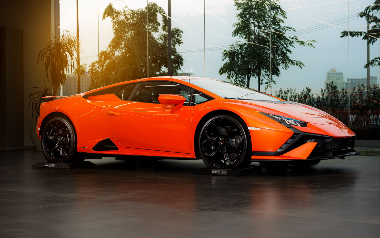 Orange Lamborghini Huracán Tecnica in a glass-walled showroom