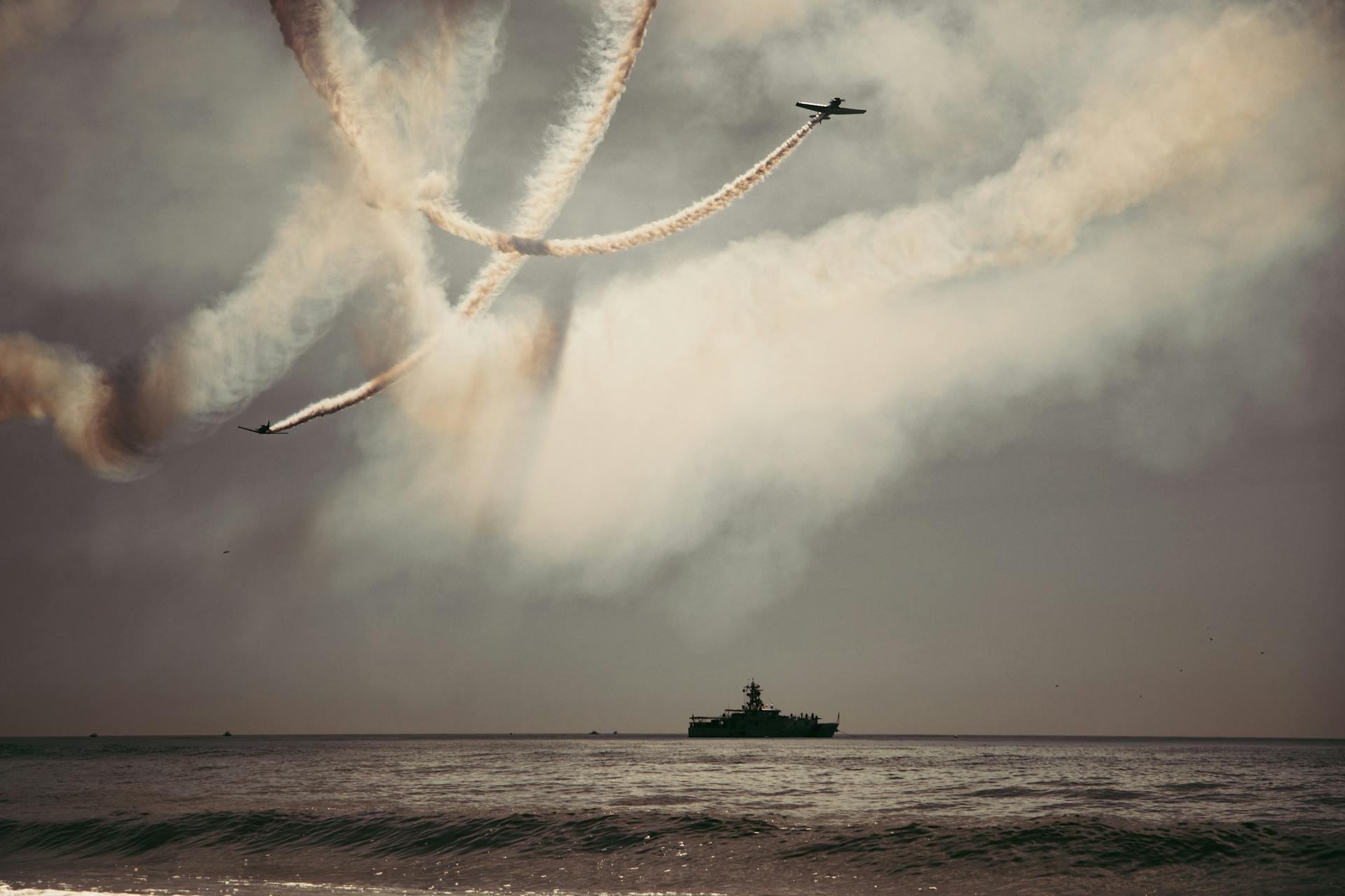 Dynamic aerial display with contrails and ship in New York's waters.