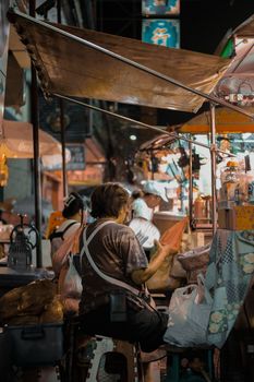 Explore the bustling ambiance of a Bangkok night market, showcasing street vendors in traditional settings.