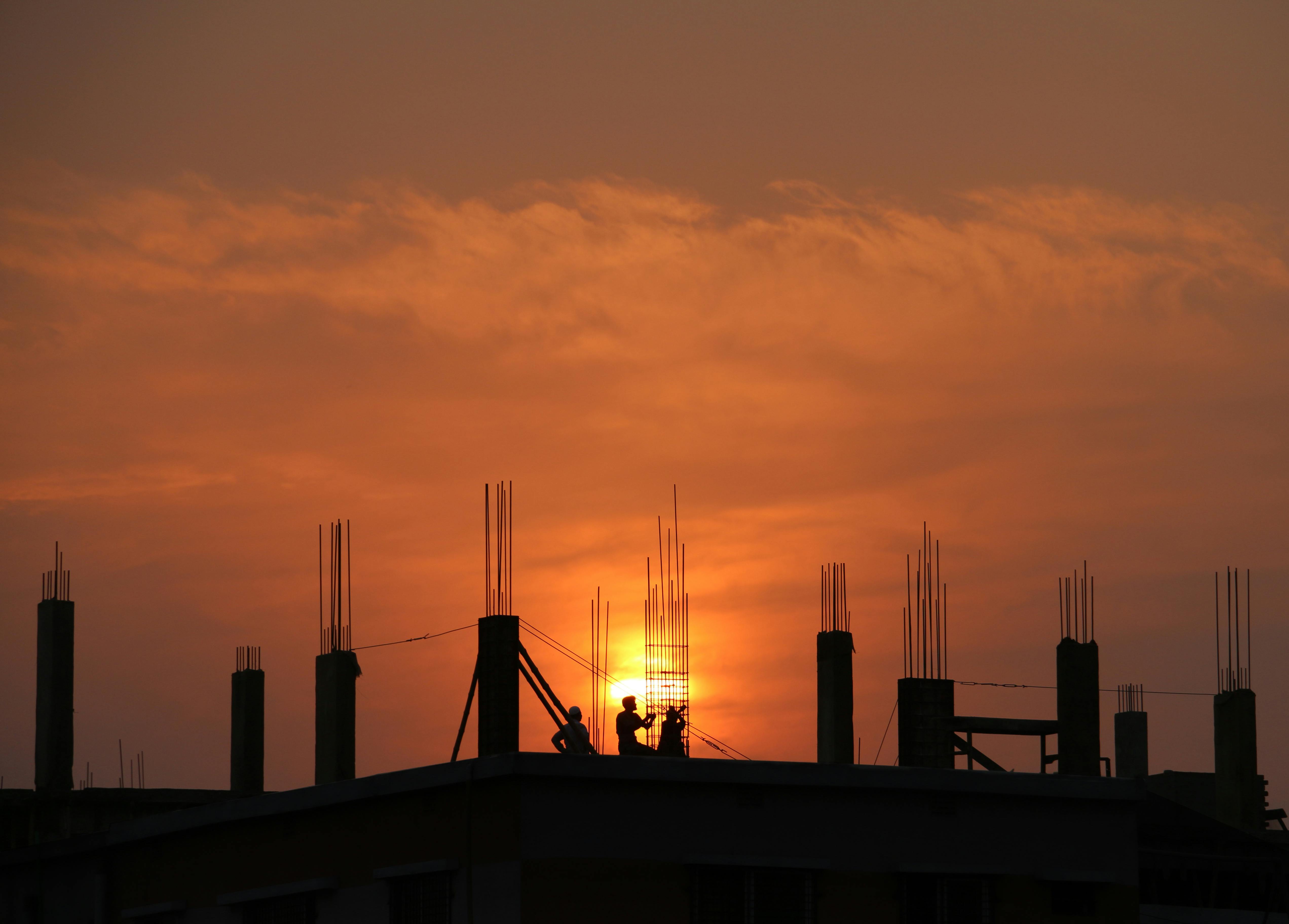 silhouette of men in construction site during sunset