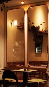 Warm and intimate cafe setting with stylish wooden furniture and soft lighting.