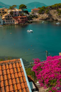 Picturesque coastal view of Kefalos, Greece with vibrant flowers and colorful buildings.