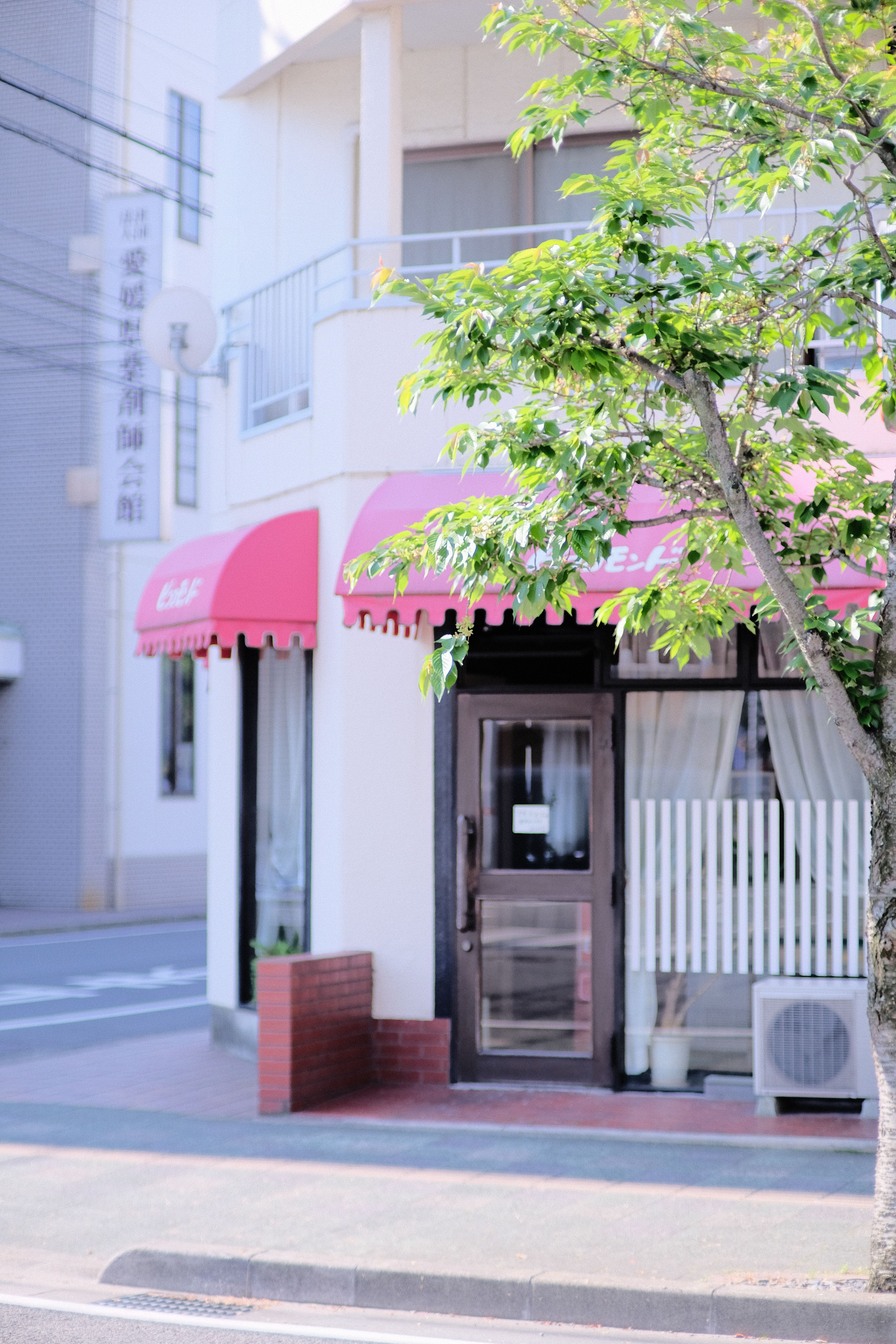 A cozy café corner with red awnings in an urban setting, perfect for a city retreat.