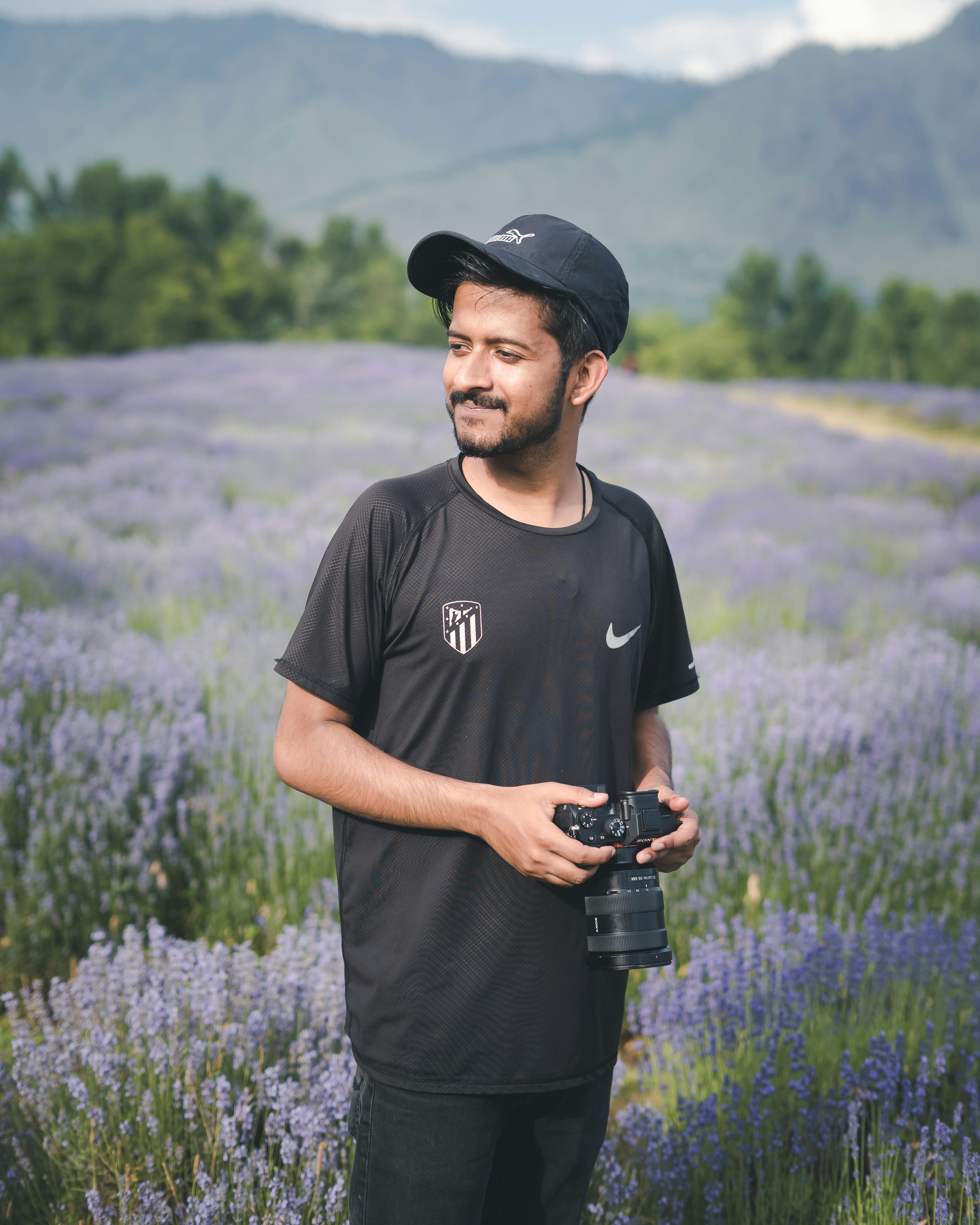 Portrait of a man standing in a lavender field holding a camera, Bijbehara.
