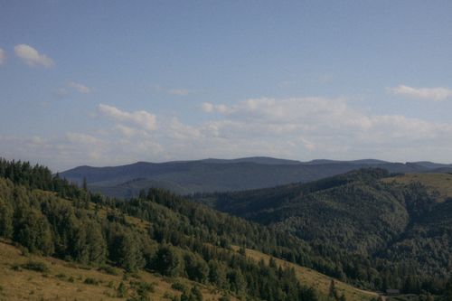 Free Serene view of lush green hills and dense forests under a clear blue sky. Stock Photo